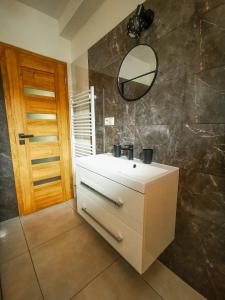 a bathroom with a white sink and a mirror at Koliba Pod Skalami in Súľov-Hradná