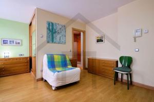 Un dormitorio con una cama y una silla verde. en Loft en Oviedo - Ideal para 3 personas, en Oviedo
