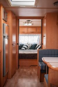 ein Schlafzimmer mit einem Bett auf der Rückseite eines Van in der Unterkunft Przyczepa w pierwszej linii brzegowej - Kemping Molo Surf in Jastarnia