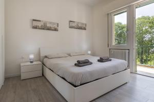 um quarto branco com uma cama grande e uma janela em Treviso to Venice - By Flora em Treviso