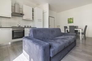 uma sala de estar com um sofá azul numa cozinha em Treviso to Venice - By Flora em Treviso