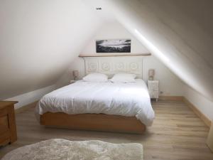 um quarto com uma cama branca num sótão em maison au calme à Lannion entre mer et ville em Lannion