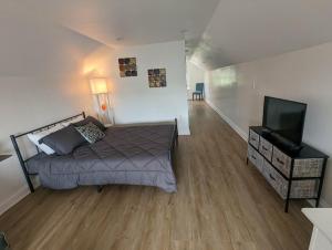a bedroom with a bed and a flat screen tv at Downtown Retreat - 1BR Oasis with Parking in Columbus