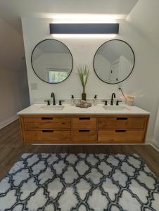 a bathroom with two sinks and two mirrors at Downtown Retreat - 1BR Oasis with Parking in Columbus