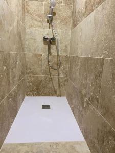 y baño con ducha y pared de azulejos. en Gite "La Coline d'Océane" - Neffies en Néffiès