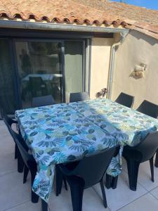 una mesa con un mantel azul en el patio en Gite "La Coline d'Océane" - Neffies en Néffiès