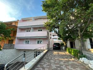 a pink building with a car parked in front of it at Moro Crikva in Crikvenica