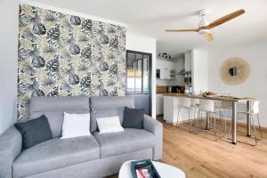a living room with a couch and a kitchen at Les Ebihens - Studio et chambre indépendante in Saint-Cast-le-Guildo