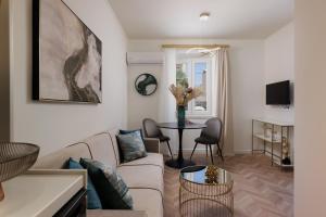 een woonkamer met een bank en een tafel bij Piazza San Rocco Apartments in Corfu-stad