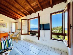 una sala de estar con ventanas y vistas al océano. en Le Terrazze Di Baja Sardinia, en Baja Sardinia
