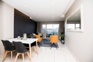 a dining room with a white table and chairs at Unit 416 at Menlyn Place in Pretoria