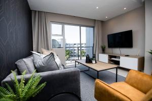 a living room with a couch and a tv at Unit 416 at Menlyn Place in Pretoria