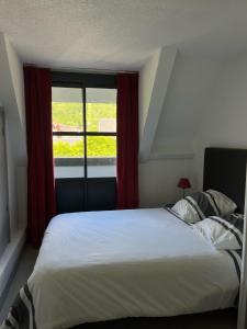 een slaapkamer met een groot bed en een raam bij appartement 6/7 personnes in Saint-Lary-Soulan