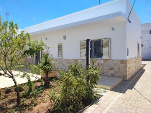 a white house with trees in front of it at SEA ROOM A TORRE LAPILLO - Guest House in Torre Lapillo