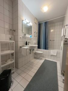 La salle de bains blanche est pourvue d'un lavabo et de toilettes. dans l'établissement FeWo Hamel, à Kehl