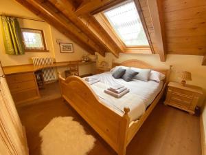 a bedroom with a large wooden bed in a attic at Vacanza da sogno nell’Altopiano. in Gallio