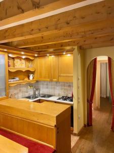 a kitchen with wooden cabinets and a stove top oven at Vacanza da sogno nell’Altopiano. in Gallio