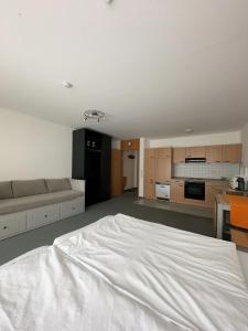 Cet appartement comprend une chambre avec un lit blanc et une cuisine. dans l'établissement FeWo Hamel, à Kehl