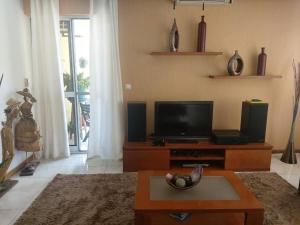 a living room with a tv and a coffee table at Apartamento acolhedor na Cidade da Praia in Praia