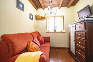 een woonkamer met een rode bank en een raam bij Ca PilaronaLa CuadraMallecina in Salas