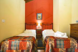 2 camas en una habitación con paredes rojas en Ca PilaronaLa CuadraMallecina, en Salas