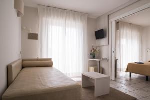 a living room with a couch and a large window at Hotel Gabriella in Rimini