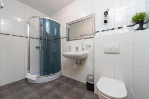 uma casa de banho com um chuveiro, um lavatório e um WC. em Tramonto em Zadar