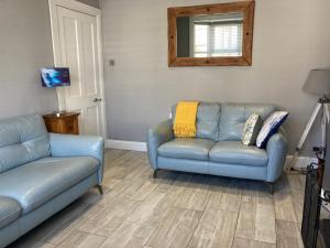 Hidden Gem في بورتراش: غرفة معيشة مع كنبتين زرقاوين ومرآة