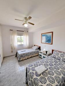 een slaapkamer met 2 bedden en een plafondventilator bij Emma's Place, 2 bedroom apartment with pool view in Paphos City