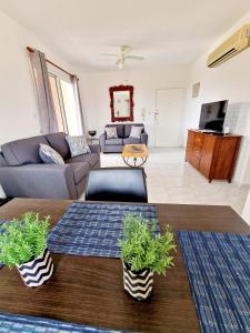 un soggiorno con divano e tavolo di Emma's Place, 2 bedroom apartment with pool view a Paphos