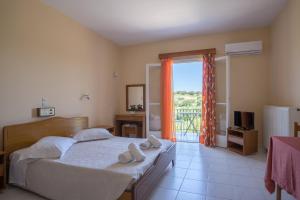 a bedroom with a bed with two towels on it at Ammousa Hotel Apartments in Lixouri