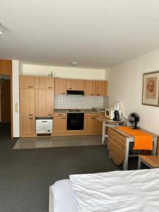 - une cuisine avec des placards en bois et un lit dans une chambre dans l'établissement FeWo Hamel, à Kehl