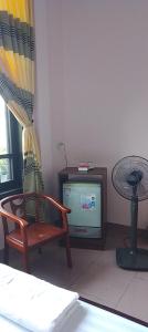 - un salon avec une chaise et une télévision dans l'établissement Nhà nghỉ Hằng Nga, à Dong Hoi