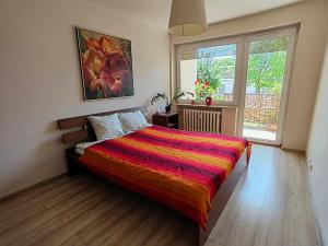a bedroom with a bed with a colorful blanket on it at La Rosa in Gdańsk