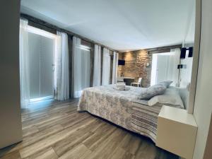 - une chambre avec un lit dans une pièce dotée de fenêtres dans l'établissement Hospedaje CasaSampedro, à Muros