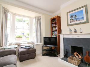 a living room with a fireplace and a tv at Mayflower, 9 Coronation Road in Salcombe