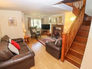 a living room with a couch and a staircase at Lavender Cottage, Brailes in Lower Brailes