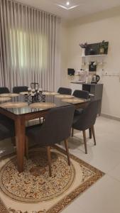 a dining room with a table and chairs on a rug at شقة كبيرة عائلية VIP حي الوادي in Riyadh