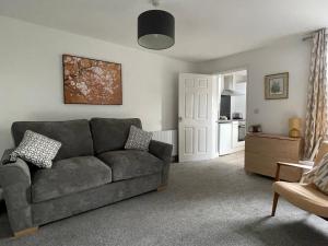 a living room with a couch and a kitchen at Cosy & Comfortable Apartment w/Parking in Worksop