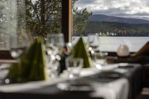 a table with wine glasses and a view of a lake at Lapland Hotels Hetta in Enontekiö