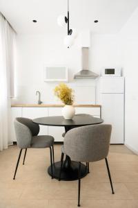 a kitchen with a table and two chairs at Blanq Marina Suites in Valencia