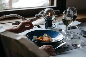 een persoon aan een tafel met een bord eten bij Lapland Hotels Hetta in Enontekiö