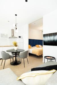 a living room with a table and a bedroom at Blanq Marina Suites in Valencia