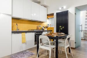 a kitchen with a black table and white cabinets at Central with hydromassage shower and elevator in Perugia