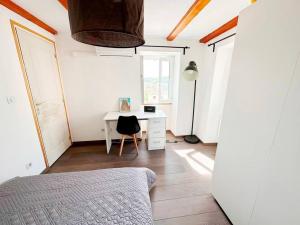 a bedroom with a desk and a table with a chair at Magnifique duplex de 130 m² à Corte (centre ville) in Corte