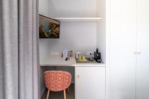 a small kitchen with a desk and a chair at Castelo Guest House in Carvoeiro