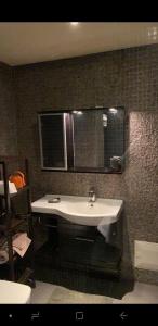 La salle de bains est pourvue d'un lavabo blanc et d'un miroir. dans l'établissement Appartement cosy, terrasse , gueliz,, à Marrakech