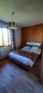 a bedroom with a large bed with a wooden wall at ISA ET LIO in Chavanod