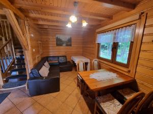 a living room with a couch and a table in a cabin at Domek Nad Stawem I in Limanowa
