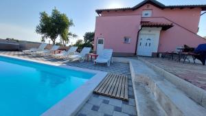 a villa with a swimming pool in front of a house at Vila Neyra in Pula